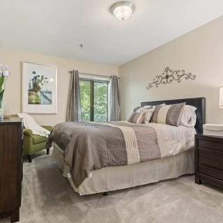 A cozy and well-decorated bedroom featuring a comfortable bed, elegant furniture, and artwork on the walls.