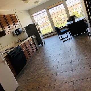 A spacious kitchen with wooden cabinets and a dining area filled with natural light.