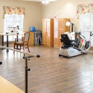 A spacious physical therapy room equipped with various tools for rehabilitation and exercise.