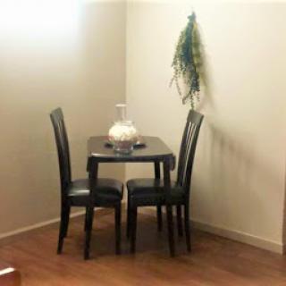 A cozy dining nook featuring a small table and two chairs, complemented by simple decor.