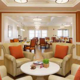 A cozy interior with comfortable seating and a dining area in the background.