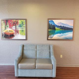 A cozy seating area featuring two colorful paintings on the wall.