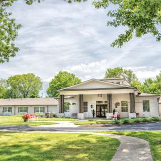 A scenic view of a building surrounded by lush greenery and a clear sky.