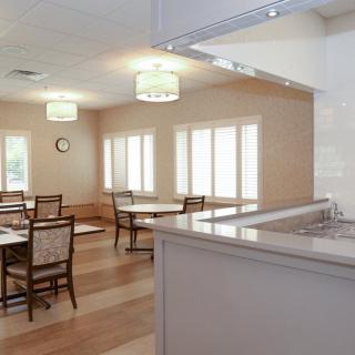 A well-lit dining area with tables and chairs arranged neatly.
