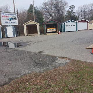 A row of storage garages with a business sign in a rural setting.