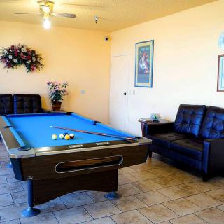 A cozy game room featuring a billiards table and comfortable seating.