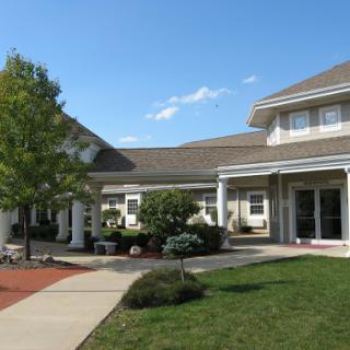 A charming residential building with a welcoming front yard and clear blue skies.