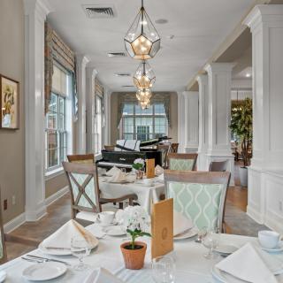 An elegant restaurant dining room with neatly set tables and stylish chandeliers.