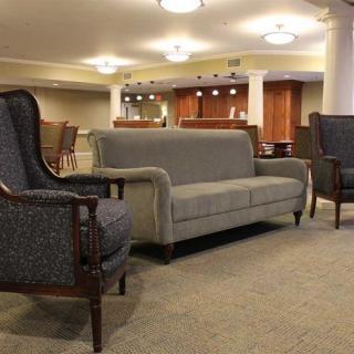 A spacious lobby area with comfortable seating including a sofa and armchairs, complemented by modern lighting and elegant interior design.