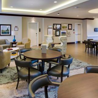 A modern lounge area with multiple seating arrangements and decorative wall art.