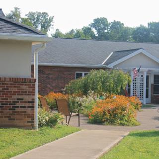 A serene residential building with a lush garden and pathway.
