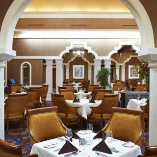 An elegant restaurant dining room with beautifully set tables and classic decor.