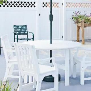 A cozy outdoor patio setting with a white table and chairs, perfect for relaxing.