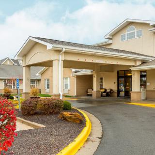 A building entrance with a covered driveway and landscaped surroundings.