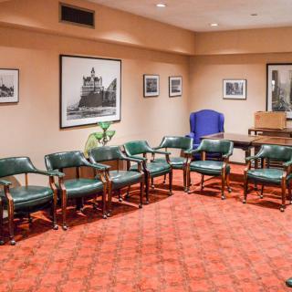A conference room with green chairs arranged in a circle and artwork on the walls.