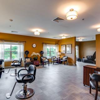 A spacious salon interior featuring styling chairs, mirrors, and a comfortable waiting area.