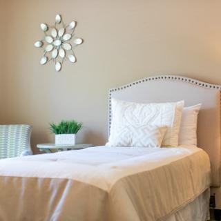 A serene and minimalist bedroom featuring a cozy bed, elegant decor, and soft natural tones.