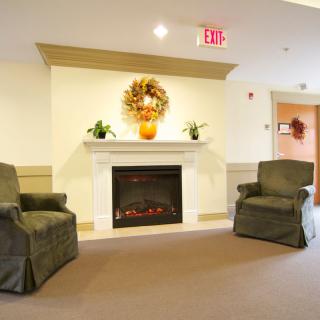 A cozy living room with a decorated fireplace and two armchairs.