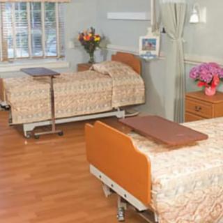 A hospital room with two beds and floral decorations.