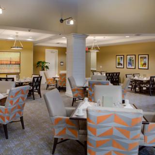 A well-decorated dining room with neatly arranged tables and patterned chairs.
