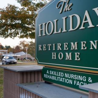 Sign for The Holiday Retirement Home, a skilled nursing and rehabilitation facility.