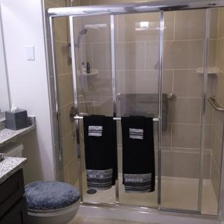 A modern bathroom with a glass shower enclosure and neatly arranged towels.