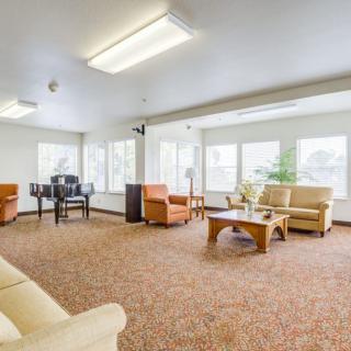 A spacious and well-lit living room with comfortable seating and large windows.