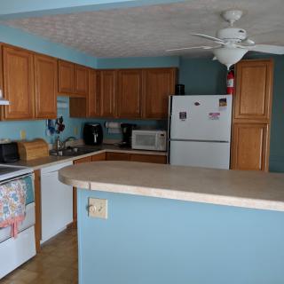 A kitchen with wooden cabinets, a large refrigerator, and various appliances on the counter.