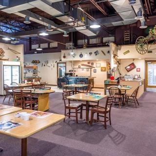A cozy restaurant dining area with wooden tables, chairs, and rustic decor.
