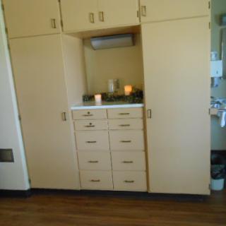 A wooden storage unit with cabinets and drawers in a hospital room.