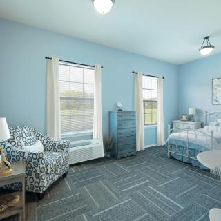 A bright and inviting bedroom with twin beds, blue walls, natural light, and cozy furnishings.