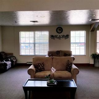 A cozy living room with sofas, a coffee table, and large windows.