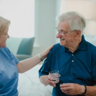 An elderly man receiving care and support from a healthcare worker.