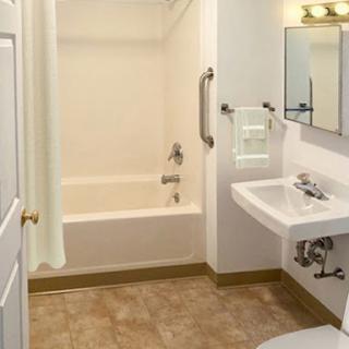 A clean and simple bathroom featuring a bathtub, sink, and modern fixtures.