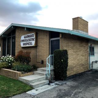 A cozy brick building with a clear sign, showcasing a welcoming entrance and well-maintained landscaping.