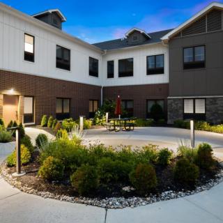 A modern building with a landscaped courtyard and evening lighting.