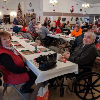 A cheerful community gathering during the holiday season, featuring seniors enjoying a meal together.