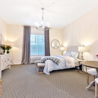 A well-lit modern bedroom with stylish decor and comfortable furnishings.