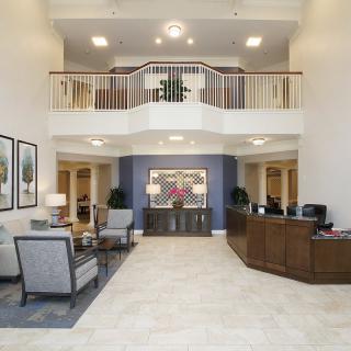 Modern hotel lobby with a reception desk and comfortable seating area.