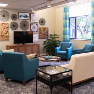 A modern living room with comfortable seating, a television, and decorative artwork on the walls.