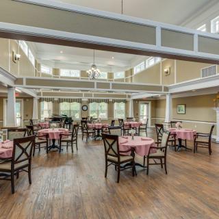 A spacious and elegantly designed dining area with tables and chairs neatly arranged under bright natural lighting.