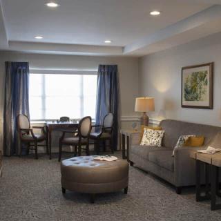 A well-designed living room featuring a cozy sofa, elegant curtains, and a decorative lamp.