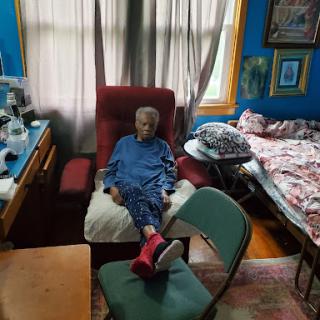 An elderly person relaxed in a cozy living room setting.