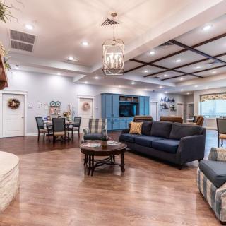 A spacious living room with an open floor plan, featuring a cozy seating area and a dining table.