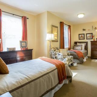 A cozy bedroom with twin beds, warm lighting, and tasteful decor.