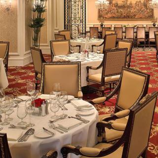 An elegant dining room with round tables and formal place settings.
