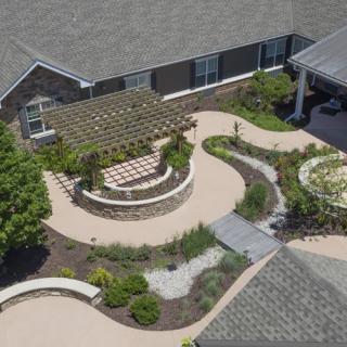 Aerial view of a landscaped patio area with a pergola and garden pathways.