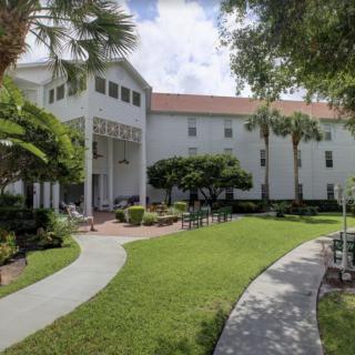A well-maintained garden with pathways and a residential building in the background.
