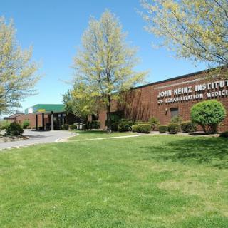 A sunny day at the John Wood Institute, surrounded by lush greenery.
