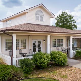 A spacious two-story house with a front porch and well-maintained landscaping.